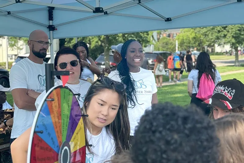 The Designer Smiles team handing out goodie bags and running a prize wheel at an Evanston community event.
