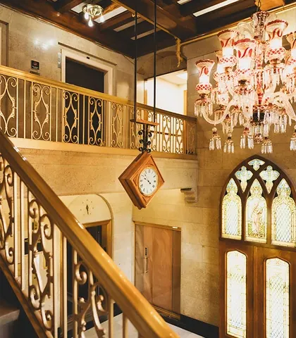 The Carlson Building's lobby: a crystal chandelier over the stair and stained-glass doors.