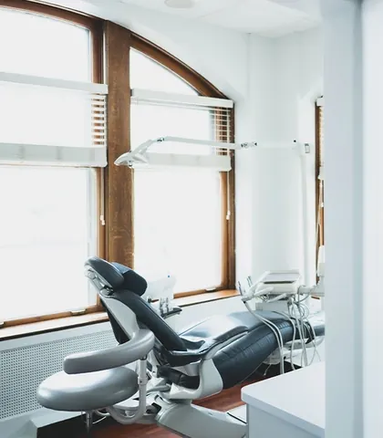 A treatment chair beside an arched window, looking out over downtown Evanston.